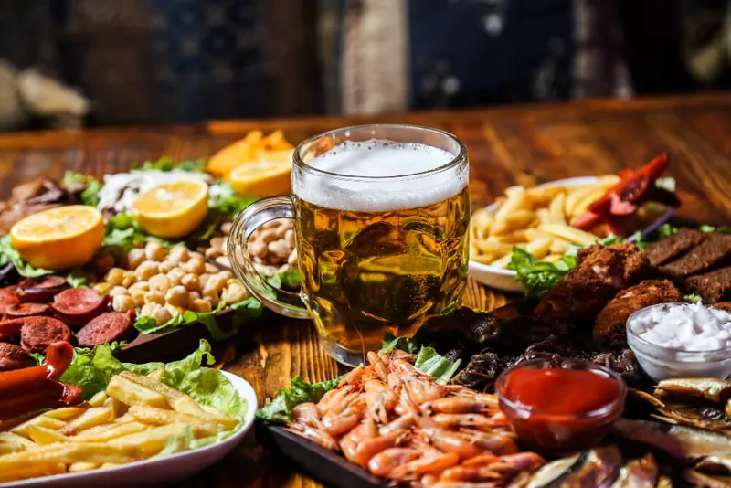 front-view-beer-snacks-with-lemon-wedges-stand-with-glass-beer